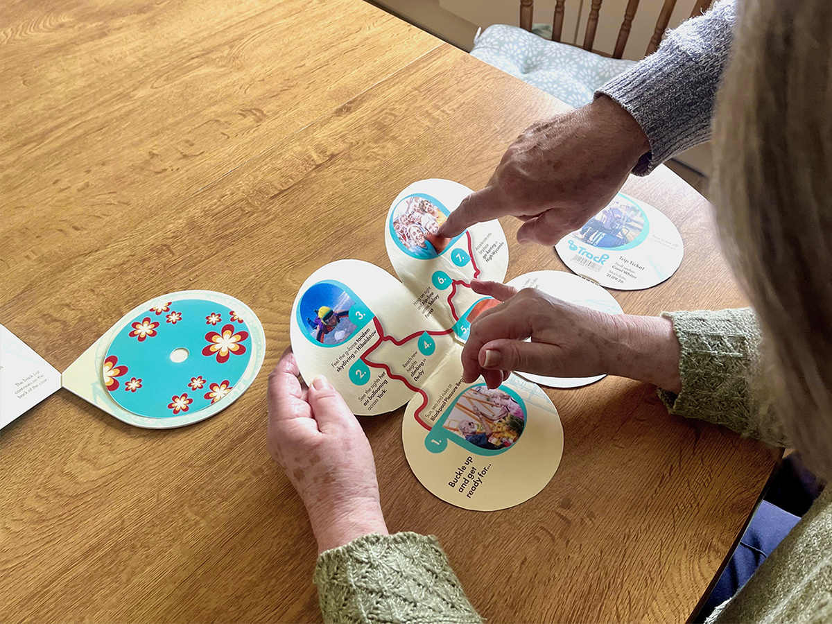 Two older people looking at the open track pack map, pointing at locations.