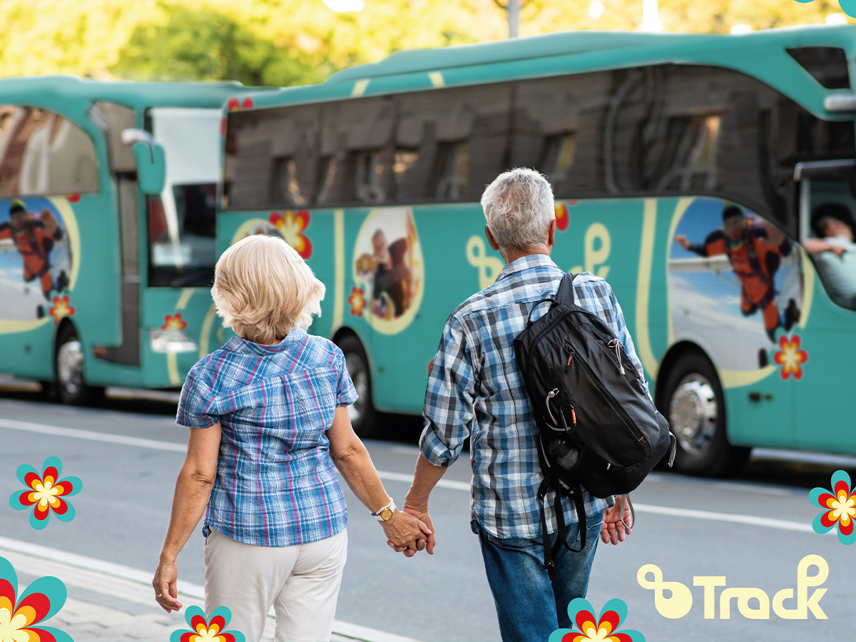 A couple walks towards two buses with 8 Track branding