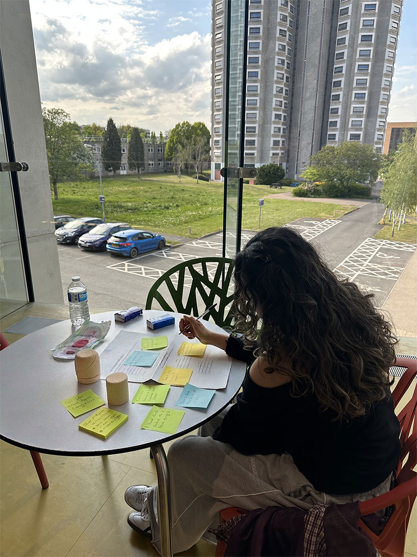 a user sitting over a table with post it notes spread in front, writing something down